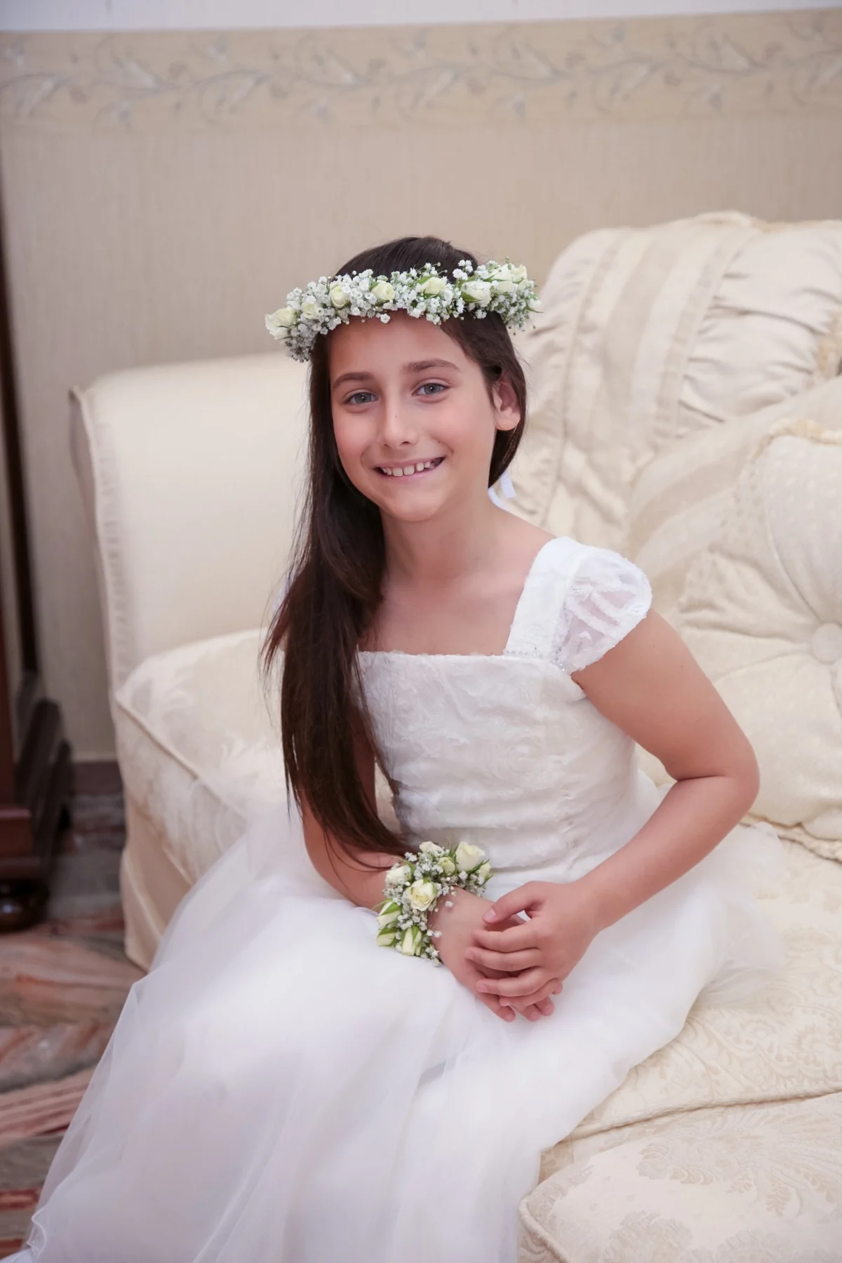 Ritratto di prima comunione con bouquet sul divano